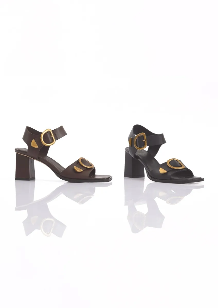 MARITZA block-heel leather sandals in dark brown and black, each with a gold ankle-strap buckle and a gold ornament on the toe strap